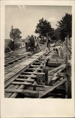 Foto Ak Bau einer Eisenbahnbrücke, Bauarbeiter, Kran