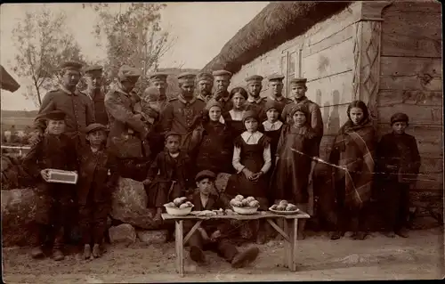 Foto Ak Deutsche Soldaten in Uniform, Aufenthalt in Kiniki Russisch Polenm Kinder in Trachten, 1. WK