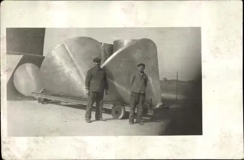 Foto Ak Zwei Arbeiter vor großen Metallteilen