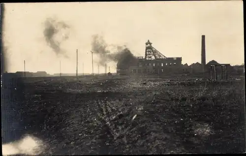 Foto Ak Blick auf eine brennende Fabrik, Förderturm, Zeche