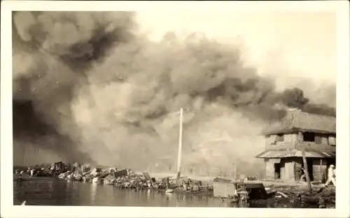 Foto Ak Philippinen ?, Brand in einem Dorf, Haus, Uferpartie, Rauchwolke