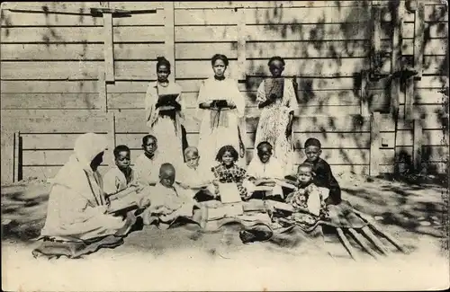 Ak Afrika, Missionsschwester, Gruppenportrait, lesende Schüler