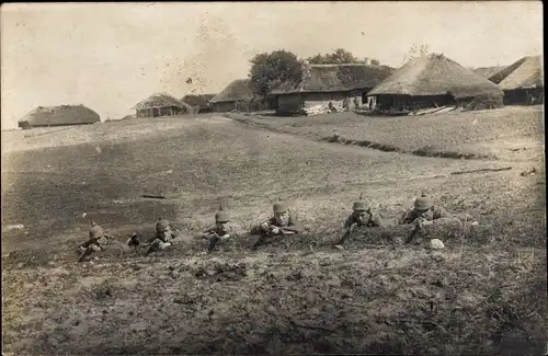 Foto Ak Deutsche Soldaten in Uniformen an der Ostfront, Dorf im Hintergrund, I WK