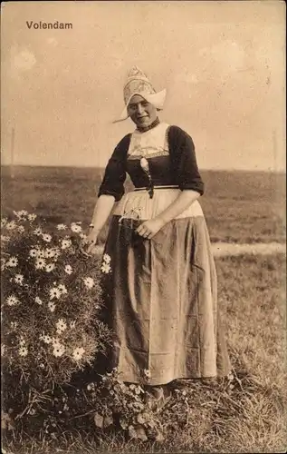 Ak Volendam Nordholland Niederlande, Frau in niederländischer Tracht, Blumen, Wiese
