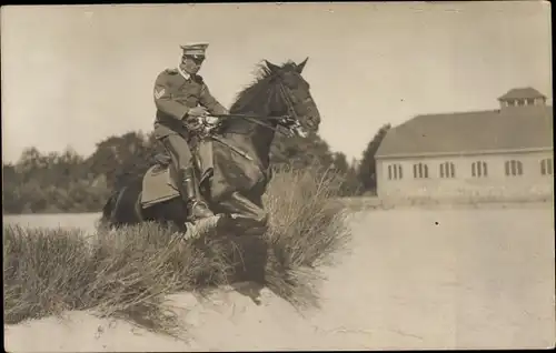 Foto Ak Deutscher Soldat in Uniform auf einem Pferd, Sprung über Hindernis, Sanddüne