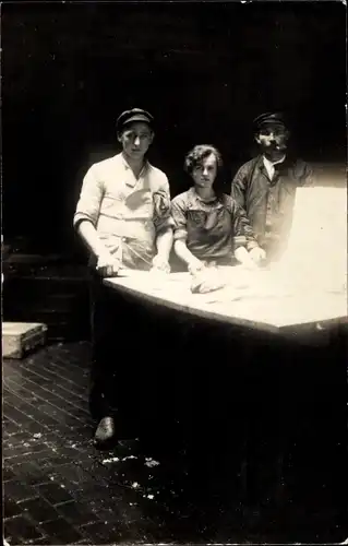 Foto Ak Arbeiter an einem Tisch mit Fischen ?, rauchender Mann, Frau