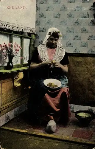 Ak Zeeland Niederlande, Frau in Tracht beim Kartoffelschälen, Holzschuhe