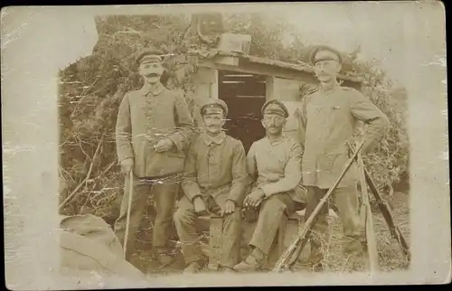 Foto Ak Deutsche Soldaten in Uniform vor einem Unterstand, Gewehre