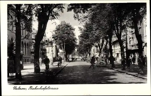 Ak Uelzen in Niedersachsen, Bahnhofstraße, Fußgänger, Bäume, Litfaßsäule, parkende Autos