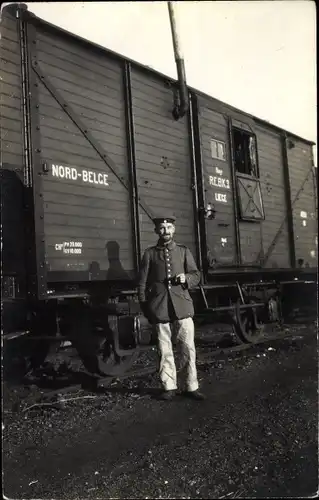Foto Ak Deutscher Soldat in Uniform vor einem Güterwaggon, Nord Belge