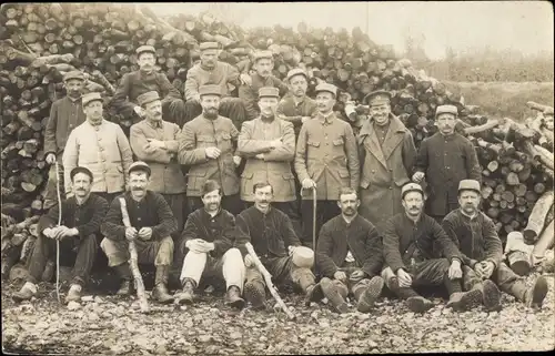 Foto Ak Französische Soldaten in Uniformen, Gruppenaufnahme vor einem Holzstapel