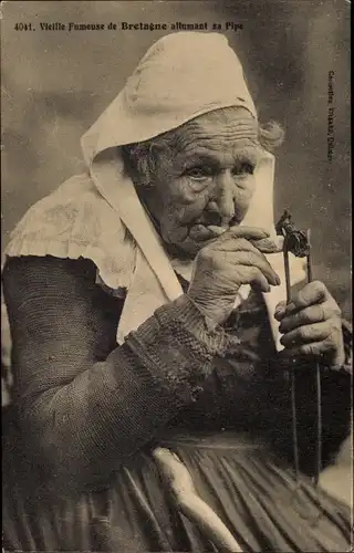 Ak Vieille Fumeuse allumant sa pipe, rauchende Frau in bretonischer Tracht