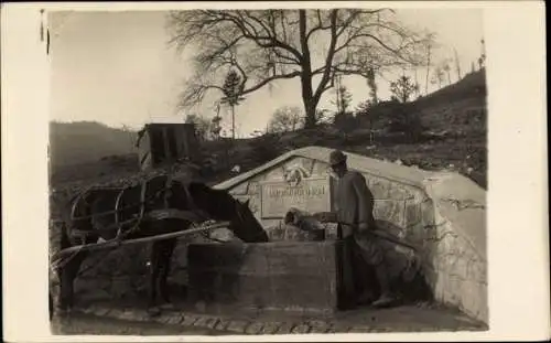 Foto Ak Mann mit Pferd an einem Brunnen in den Bergen