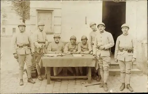 Foto Ak Französische Soldaten in Uniformen, Gruppenaufnahme 1920, Tisch, Gebäude