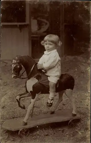 Foto Ak Kleines Kind auf einem Schaukelpferd