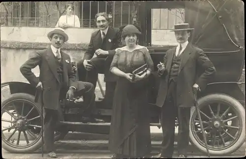 Foto Ak Männer und Frau vor einem Automobil