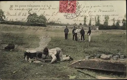 Ak En pleine Campagne, Französische Soldaten, Kessel mit Suppe, Lagerfeuer