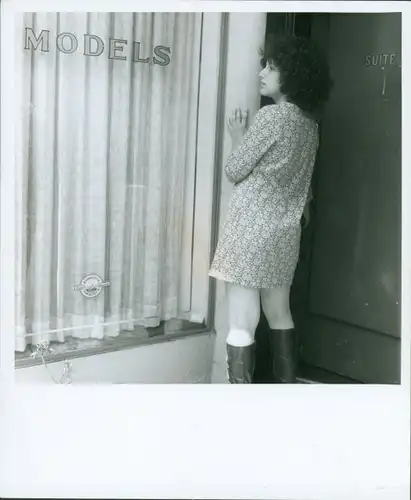 Akt Fotografie Lilo Korenjak, Frau mit kurzem Kleid und Stiefel steht an einem Fenster, "Models"
