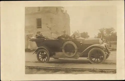 Foto Ak Personen in einem Automobil mit offenem Verdeck vor einer Hausruine