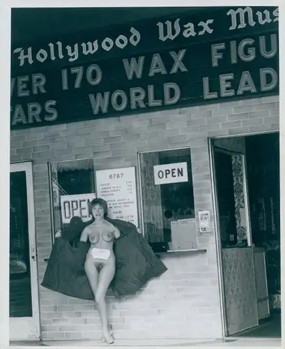 Akt Fotografie Lilo Korenjak, Frau, nackt, barbusig mit geöffnetem Mantel vor Kinokasse stehend