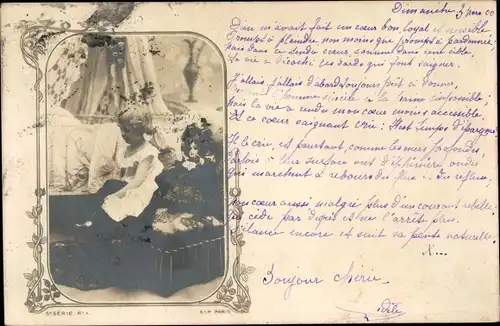 Foto Ak kleines Mädchen mit Puppe am Bett sitzend