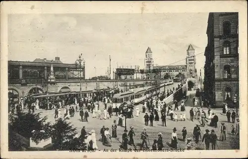 Ak Köln am Rhein, An der Rampe der Hohenzollernbrücke, Straßenbahn, Spaziergänger