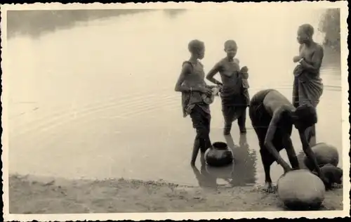 Foto Guinea, Einheimische am Ufer beim Waschen der Töpfe