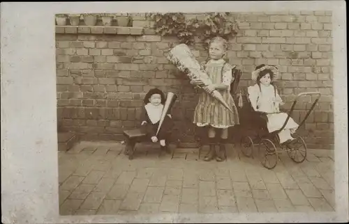 Foto Ak Einschulung, Portrait von Mädchen mit Schultüte und Mappe, Puppe im Puppenwagen