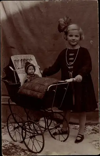 Foto Ak Mädchen im Kleid mit Schleife im Haar, Puppenwagen