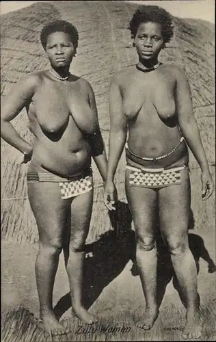 Ak Zulu Women, zwei barbusige Frauen mit Lendenschurz vor einer Hütte