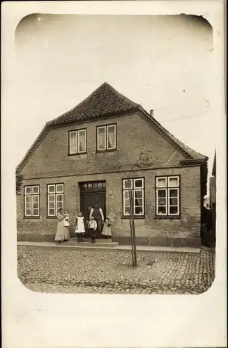Foto Ak Ostseebad Heiligenhafen in Holstein, Familie vor einem Wohnhaus