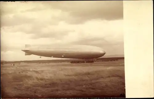 Foto Ak Zeppelin über einem Feld bei der Landung