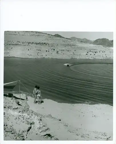 Foto Helmut Stege, Erotik, nacktes Paar am Strand beobachtet Motorboot, FKK