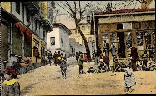 Ak Thessaloniki Griechenland, une rue de la ville haute avec une suite de decrotteurs
