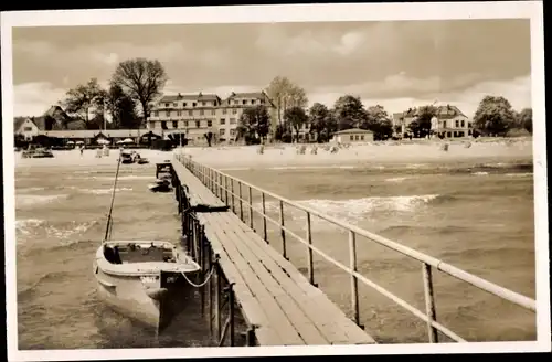 Ak Ostseebad Scharbeutz in Ostholstein, Blick vom Steg auf den Strand und Ort, Boot