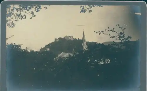 Foto Unbekannter Ort, Blick über einen Ort zur einer Burgruine, Kirchturm