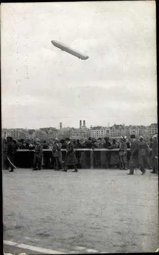 Ak Zeppelins große Fernfahrt nach München 1909, Luftschiff über der Stadt, Schaulustige
