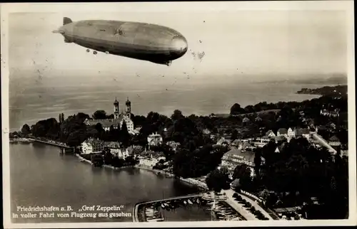 Ak Friedrichshafen am Bodensee, Luftschiff LZ 127 Graf Zeppelin über der Stadt, Fliegeraufnahme