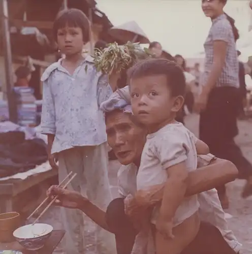 Foto Spremberg, Hans Joachim, Nha Trang Vietnam, Markt, Großmutter gibt ihrem Enkel zu essen, 1975