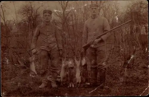 Foto Ak Zwei deutsche Soldaten in Uniformen mit erlegten Hasen, Gewehr, I WK