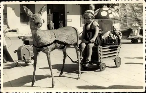 Foto Mädchen mit Spielzeugen, Handkarren, Moped im Hintergrund