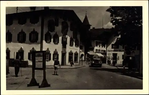 Foto Ak Oberammergau in Oberbayern, Straßenpartie, Gasthaus, Autobus, Geschäftshaus