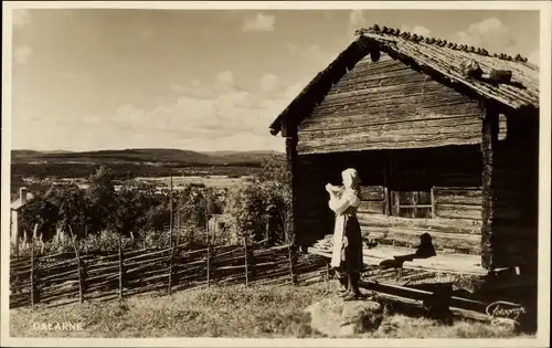 Ak Dalarne Dalarna Schweden, Frau vor einer Hütte, Panoramablick