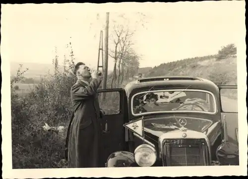 Foto Ak Mercedes Benz Automobil, Mann bei der Rast am Straßenrand
