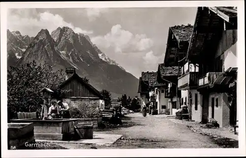 Ak Garmisch Partenkirchen in Oberbayern, Dorfstraße, Brunnen, Berge