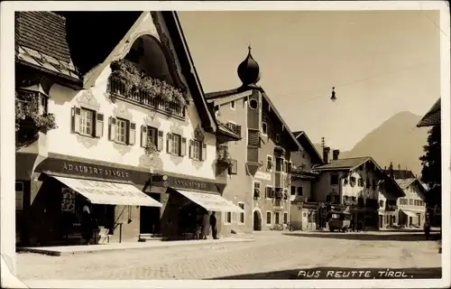 Ak Reutte in Tirol, Straßenpartie im Ort, Herrn- und Damenmode Adalbert und Anna Singer