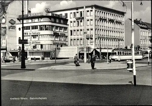 Ak Krefeld am Niederrhein, Bahnhofsplatz, Straßenbahn, Passanten, Geschäftshäuser