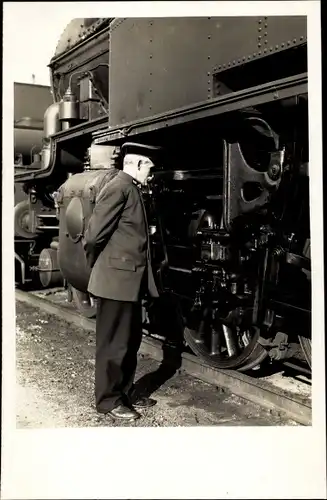 Foto Ak Eisenbahn, Dampflokomotive, Lokführer begutachtet Räder