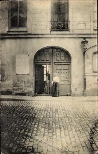 Foto Ak Paris III, zwei Personen vor einem Tor, Straßenpartie