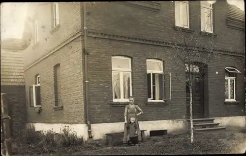 Foto Ak Gütersloh in Westfalen, Frau und Kind vor einem Wohnhaus